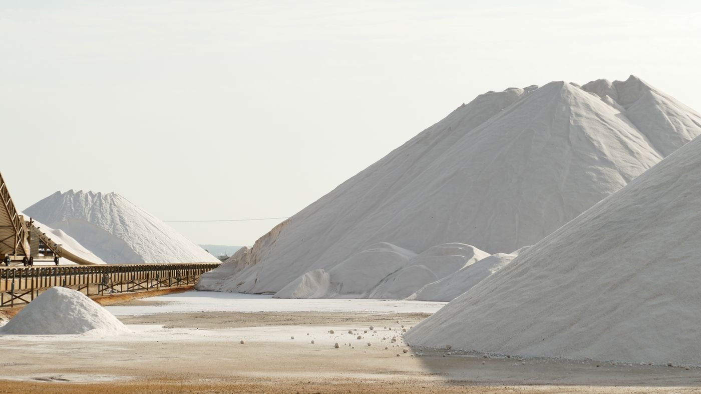 Industrial salt mountains beside a conveyor system